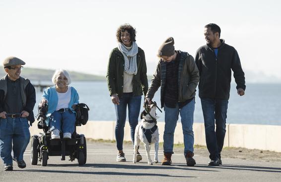 A group of people with diverse body types and abilities stroll along the Bay Trail.
