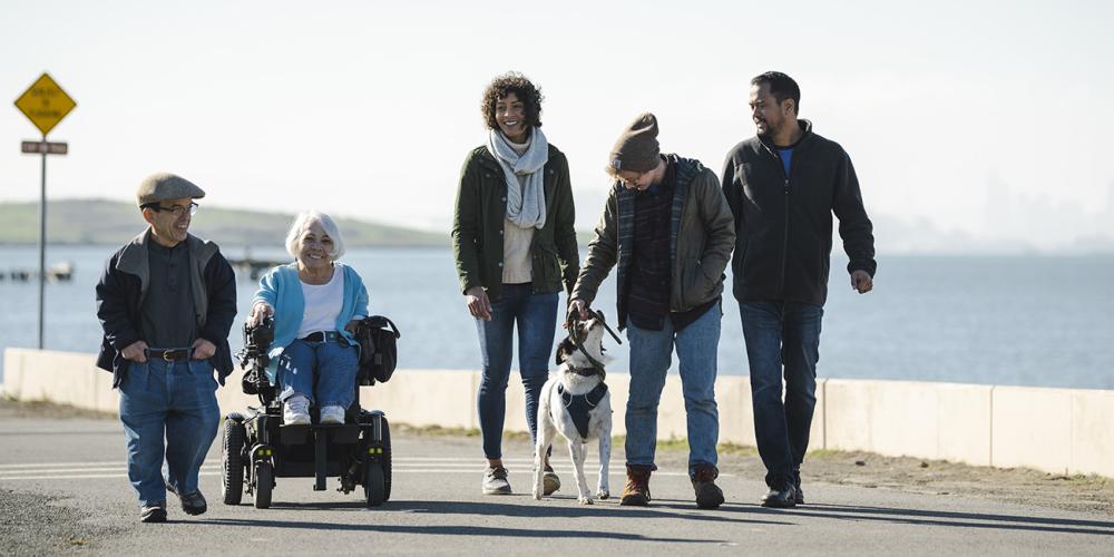 A group of people with diverse body types and abilities stroll along the Bay Trail.