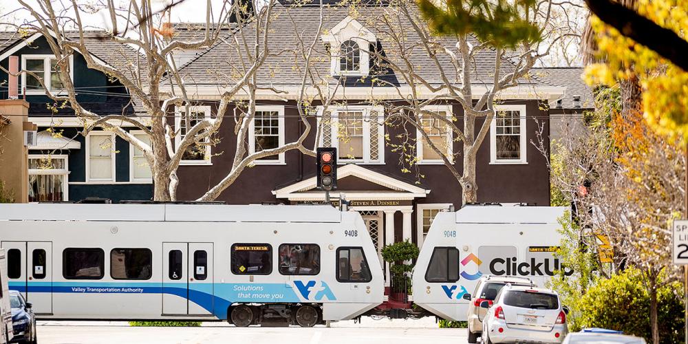 VTA light rail train near a large home on a residential street.